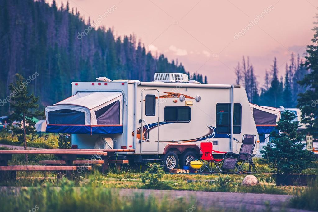 RV and tents set up at a wooded Louisiana campground at sunset